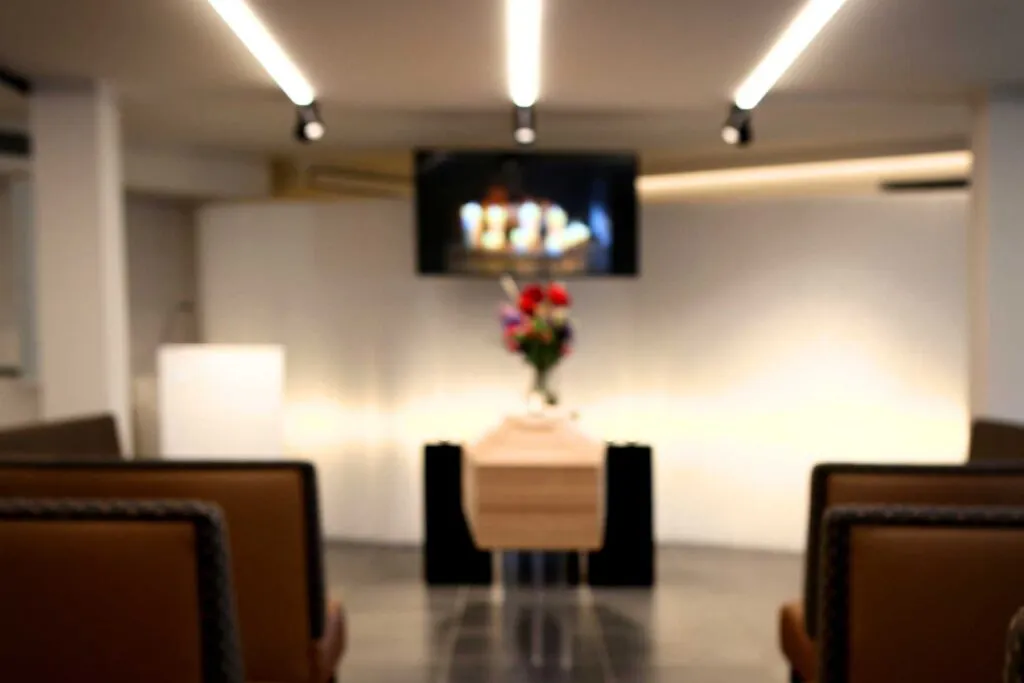 Van Kuyk Uitvaartcentrum Merksem — uitvaartaula met kist en bloemen